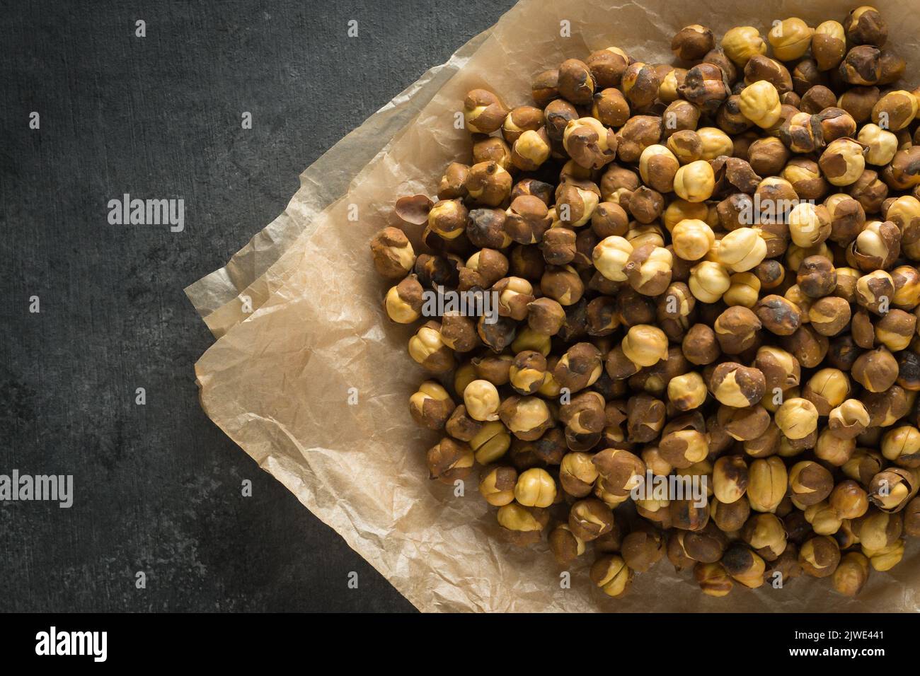 pile of roasted and salted black chickpeas, also known as bengal gram or desi chickpea, traditional and native oil free snack of india, Stock Photo