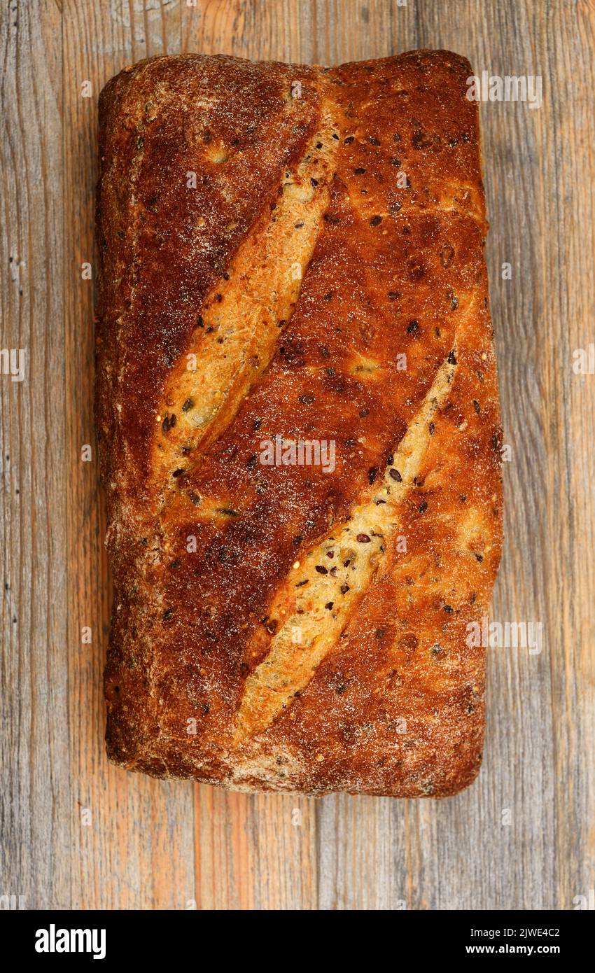 loaf of bread with seeds on wooden background Stock Photo