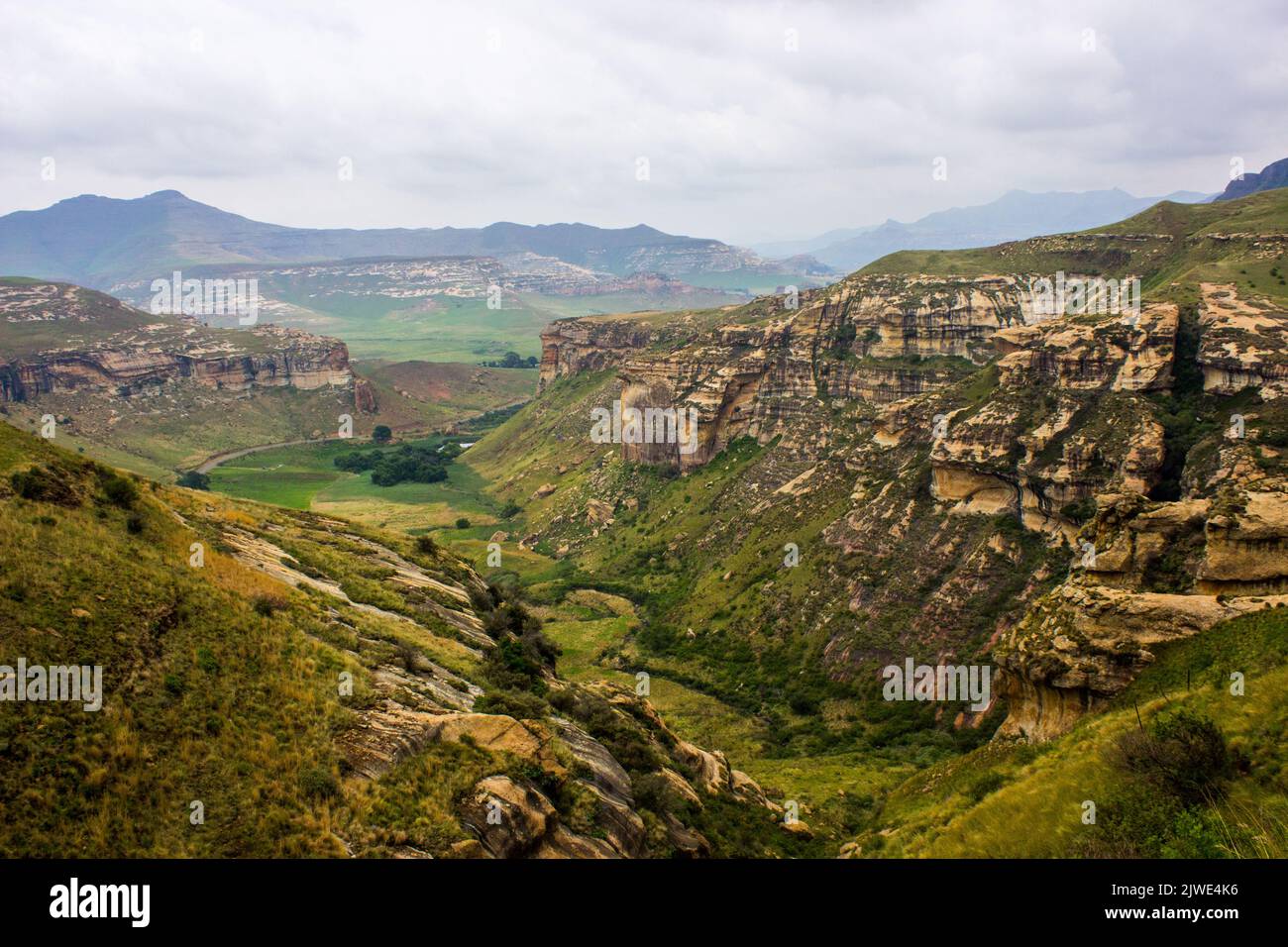 A secluded valley in the rugged Drakensberg Mountains of the Golden Gate Highlands national Par, with a summer storm gathering in the background Stock Photo