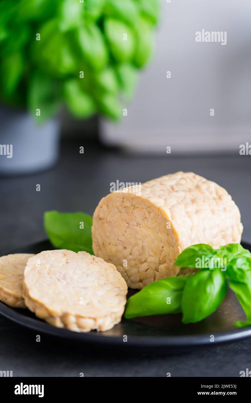 Raw Tempeh or Tempe, made of fermented soybean seeds on kitchen table