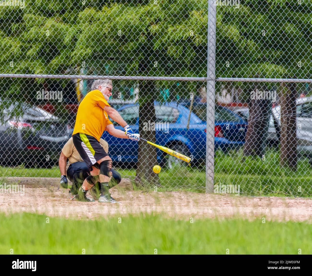 NEW ORLEANS, LA, USA - AUGUST 11, 2019: Softball batter swings and misses at pitched softball Stock Photo