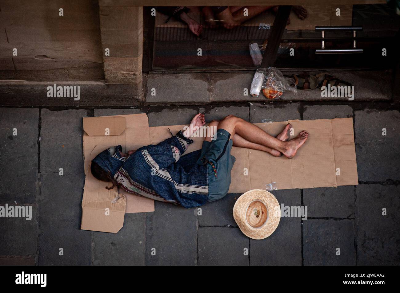 Homeless man sleeps in an alley of Barcelona's Gothic Quarter. Stock Photo