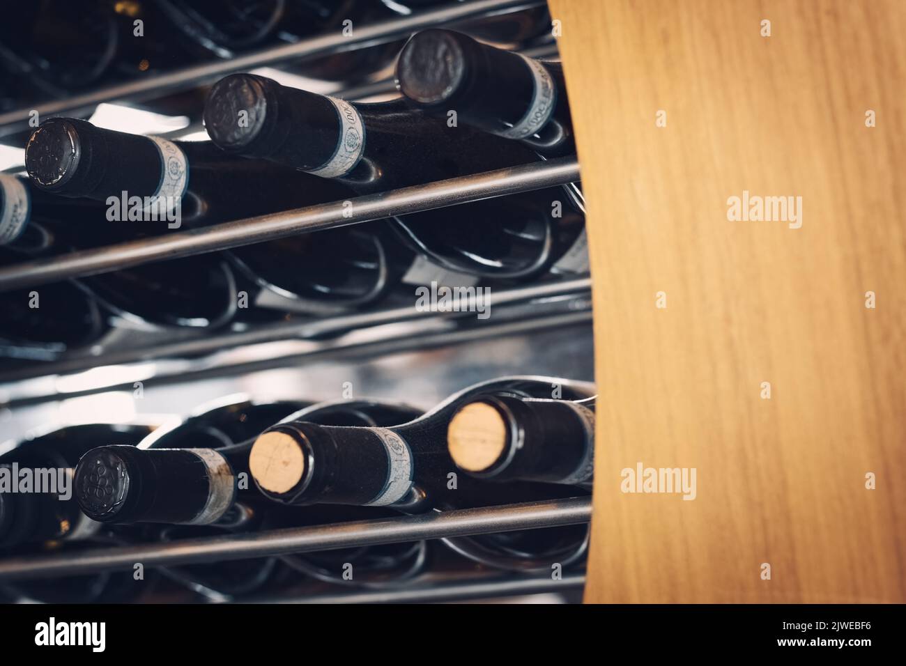Wine bottles laid horizontally in a wine rack with wood and metal bars