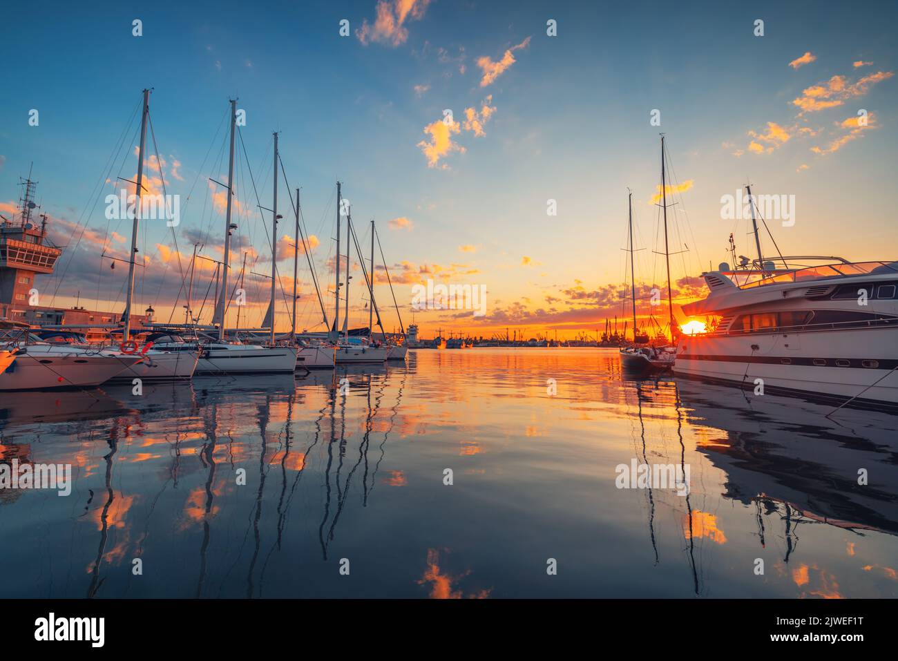 Yacht and sailboat harbor and scenic sunset over the sea. Yachts and boats on the coast. Stock Photo