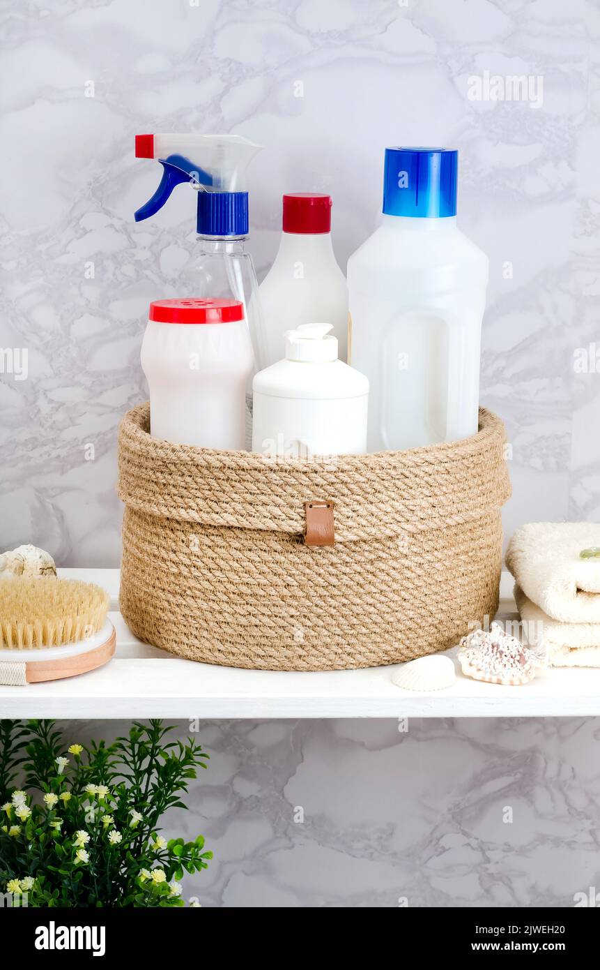 Hand knitted jute basket with a lid with detergents and towels in the