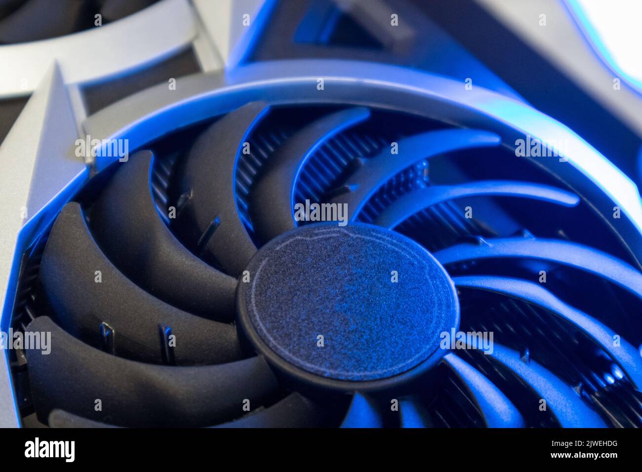 Cooler fan on Gpu graphics video card, close-up in bright blue light, PC hardware details. Components from computer cooling system with selective focu Stock Photo