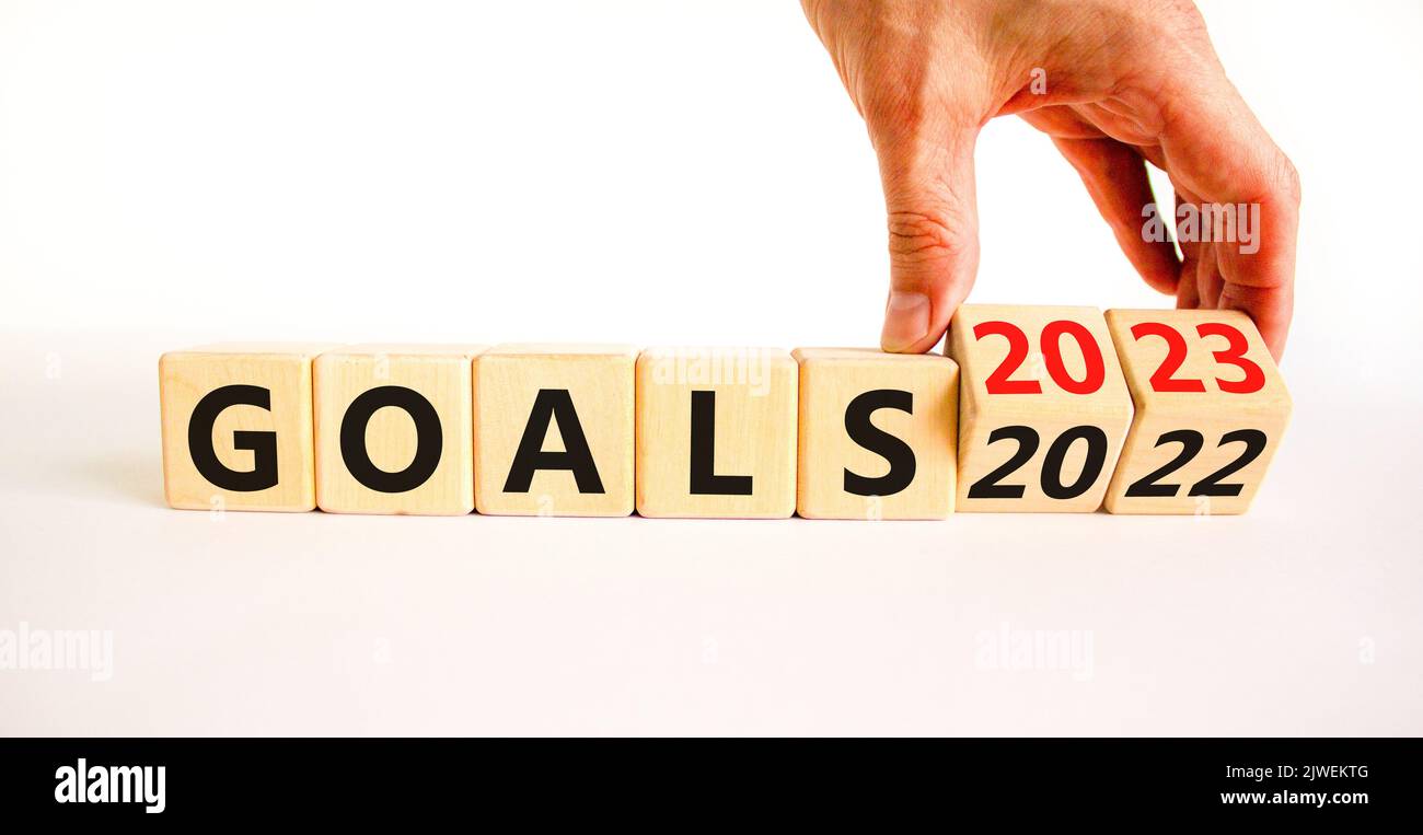 Planning 2023 goals new year symbol. Businessman turns a wooden cube