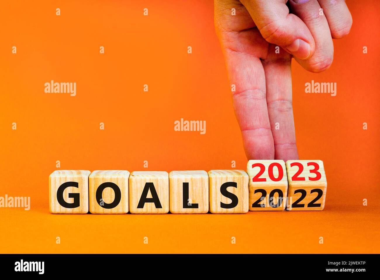 Planning 2023 goals new year symbol. Businessman turns a wooden cube