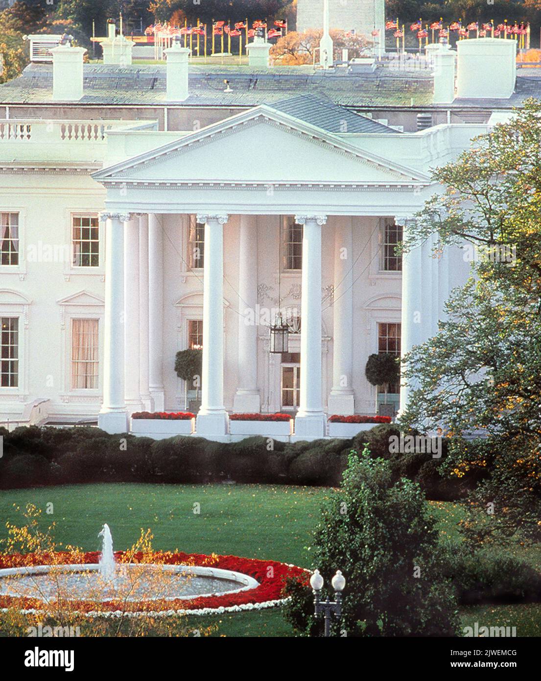 White House Washington DC Exterior North Portico. Background Circle of American flags around the Washington Monument. USA Stock Photo