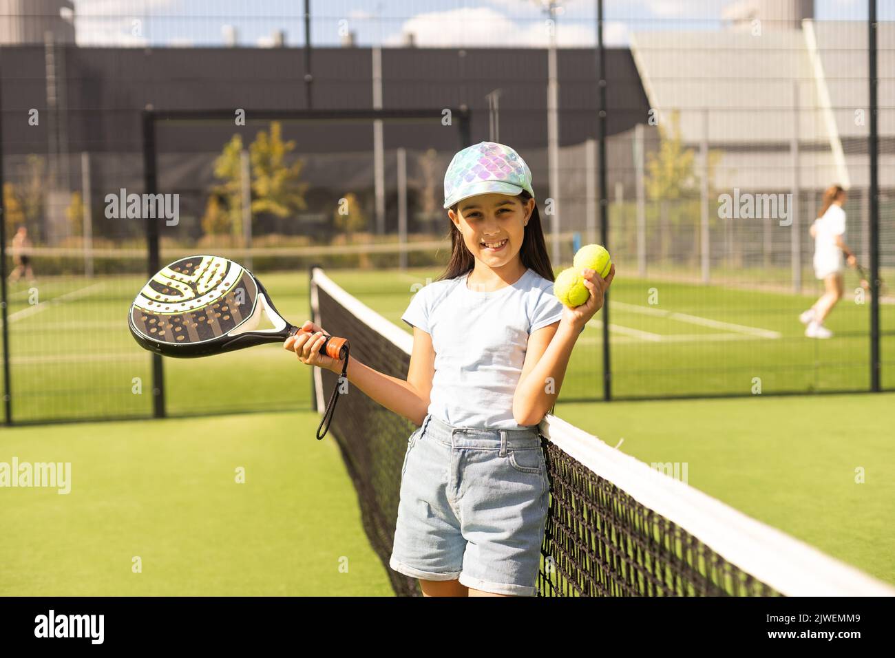 little girl with racket playing padel tennis at court Stock Photo - Alamy