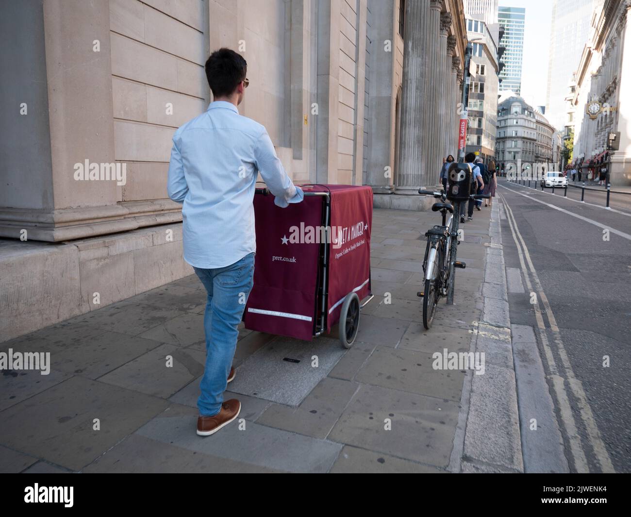 City of London UK. Pret a Manger delivery push cart operator walking past The Bank of England, Threadneedle Street, London Stock Photo