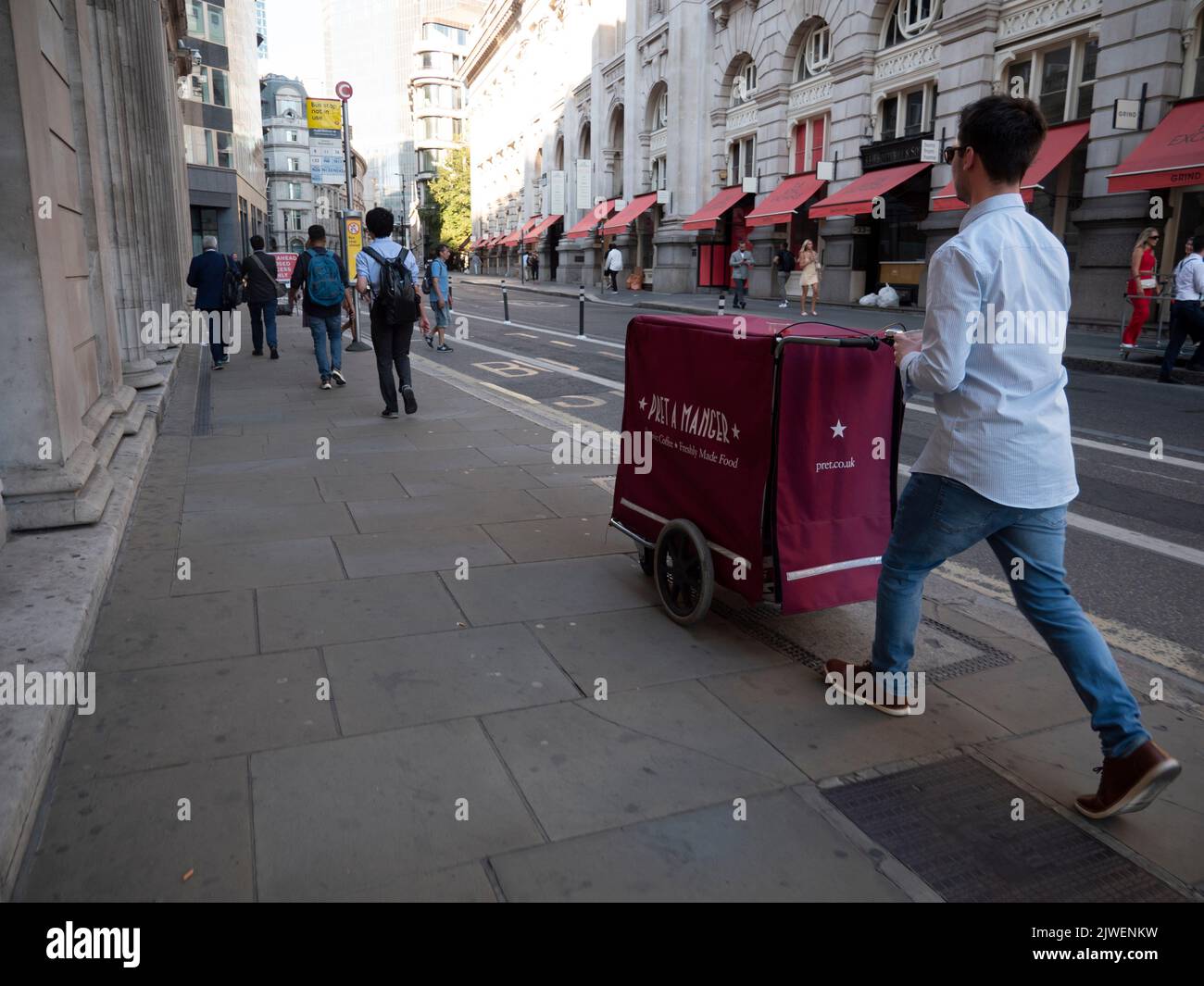 City of London UK. Pret a Manger delivery push cart operator walking past The Bank of England, Threadneedle Street, London Stock Photo