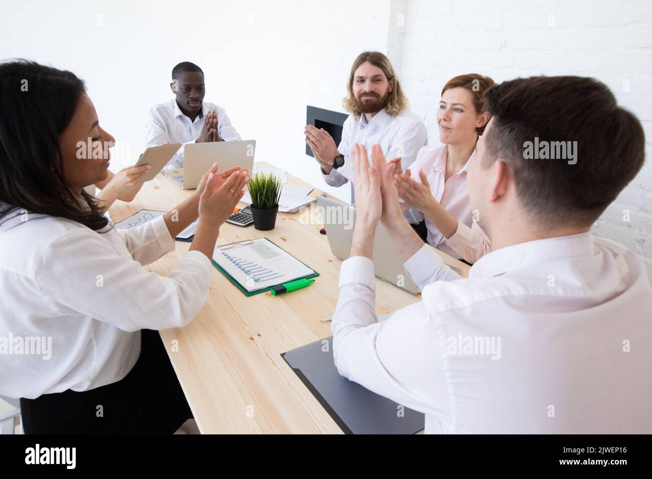 Group of business people applauding sitting at the negotiating table Stock Photo