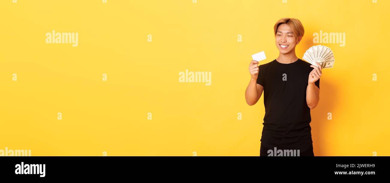 Portrait of satisfied smiling, handsome asian guy looking pleased at