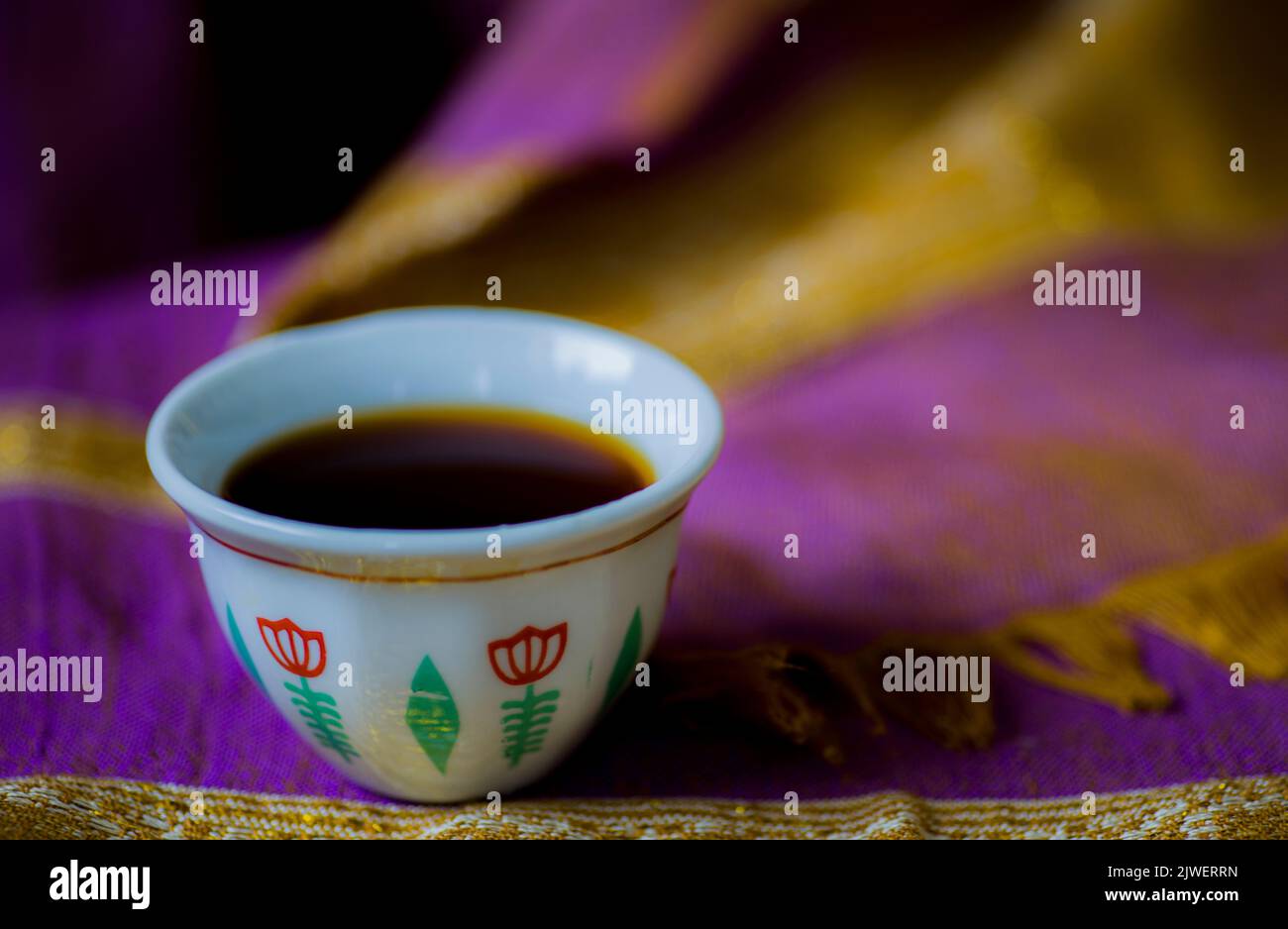 An authentic Ethiopian coffee cup, on a hand-knitted scarf, dyed by a purple herbal dye, made of the Flamingia Grahamiana plant, grown up in Ethiopia Stock Photo