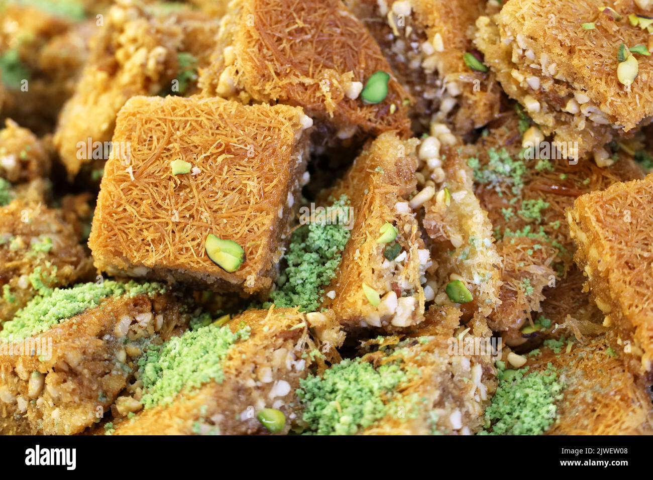 Baklava with pistachios and peanuts, sweet background. Traditional turkish and arabic dessert Kunafa with pistachio, nuts and honey Stock Photo