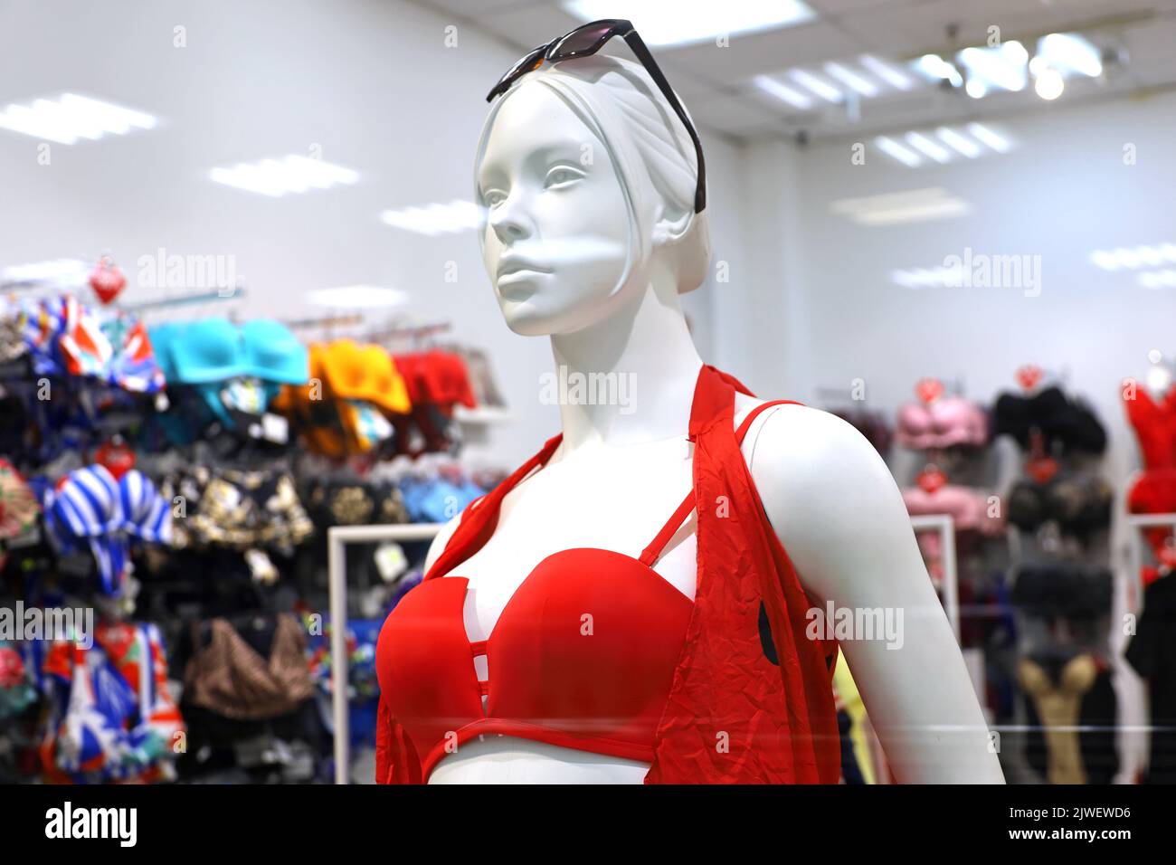 Female mannequin in red swimsuit. Lingerie store, swimwear for beach holidays, view through the glass Stock Photo