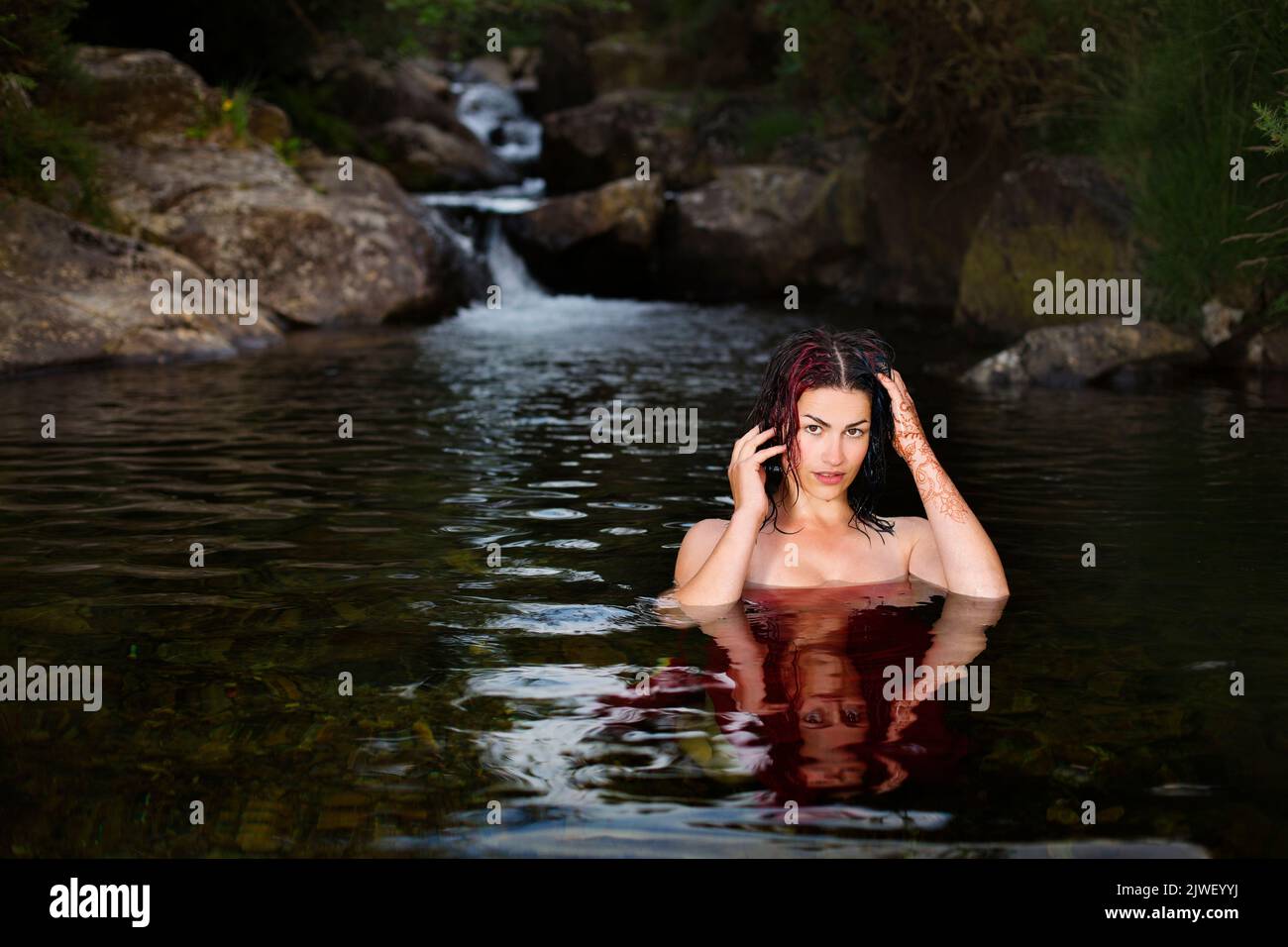 A beautiful woman cooling of in a river Stock Photo