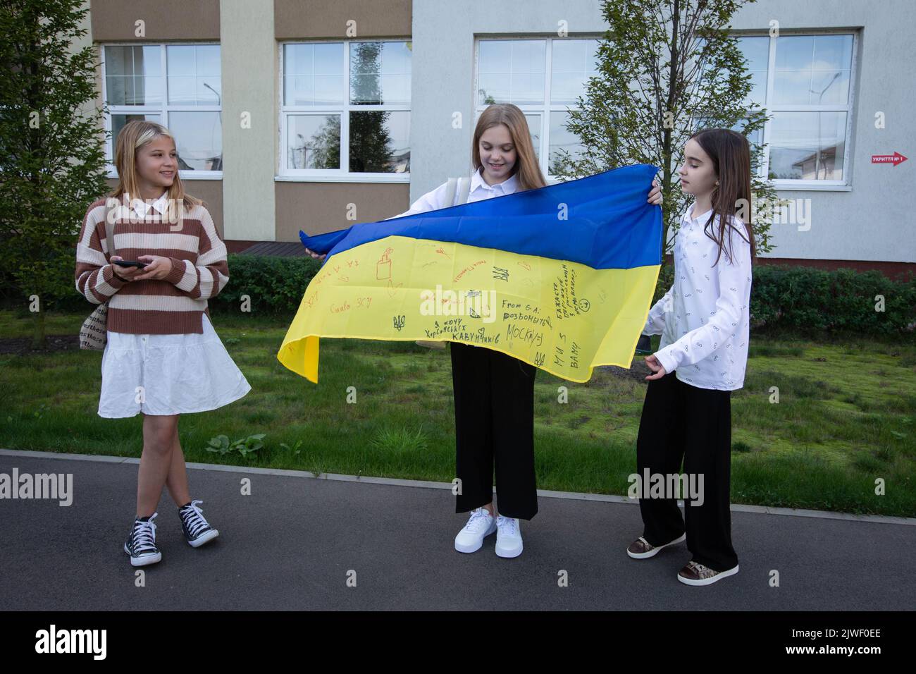 Bucha, Ukraine. 01st Sep, 2022. Schoolchildren pose for a photo with the Ukrainian national flag after a ceremony to mark the start of the school year in Bucha. A small town of Bucha in Kyiv region was liberated from Russian occupation in March 2022. Credit: SOPA Images Limited/Alamy Live News Stock Photo