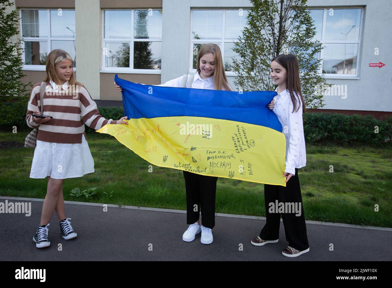Bucha, Ukraine. 01st Sep, 2022. Schoolchildren pose for a photo with the Ukrainian national flag after a ceremony to mark the start of the school year in Bucha. A small town of Bucha in Kyiv region was liberated from Russian occupation in March 2022. (Photo by Oleksii Chumachenko/SOPA Images/Sipa USA) Credit: Sipa USA/Alamy Live News Stock Photo