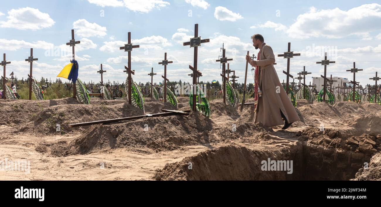 Bucha, Ukraine. 2nd Sep, 2022. A priest is seen conducting a burial ceremony. Burial of the remains of 13 unidentified and two identified people who were killed in the Buchan district during the Russian occupation, on September 2, 2022. A few months after the de-occupation of the Bucha district, those bodies that were not identified were buried and marked with numbers at the cemetery in Bucha. According to the deputy mayor of Buch Mykhailyna Skoryk, a total of 419 people who were killed during the Russian occupation of the Buchan district were buried in the city. (Credit Image: © Mykhaylo Stock Photo