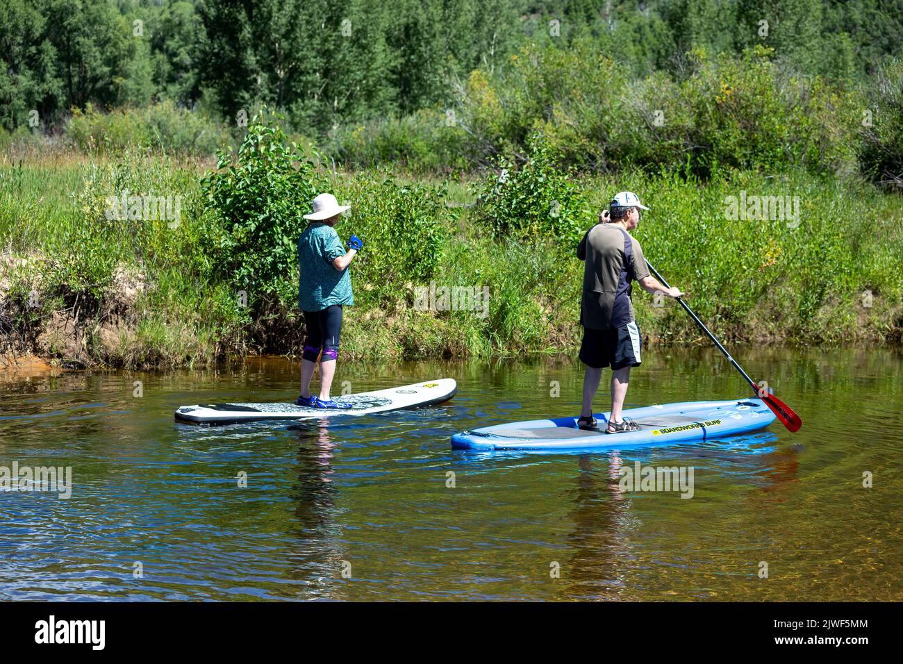 Stand up paddle boarding couple, Roaring Fork River, near Aspen, Colorado USA Stock Photo