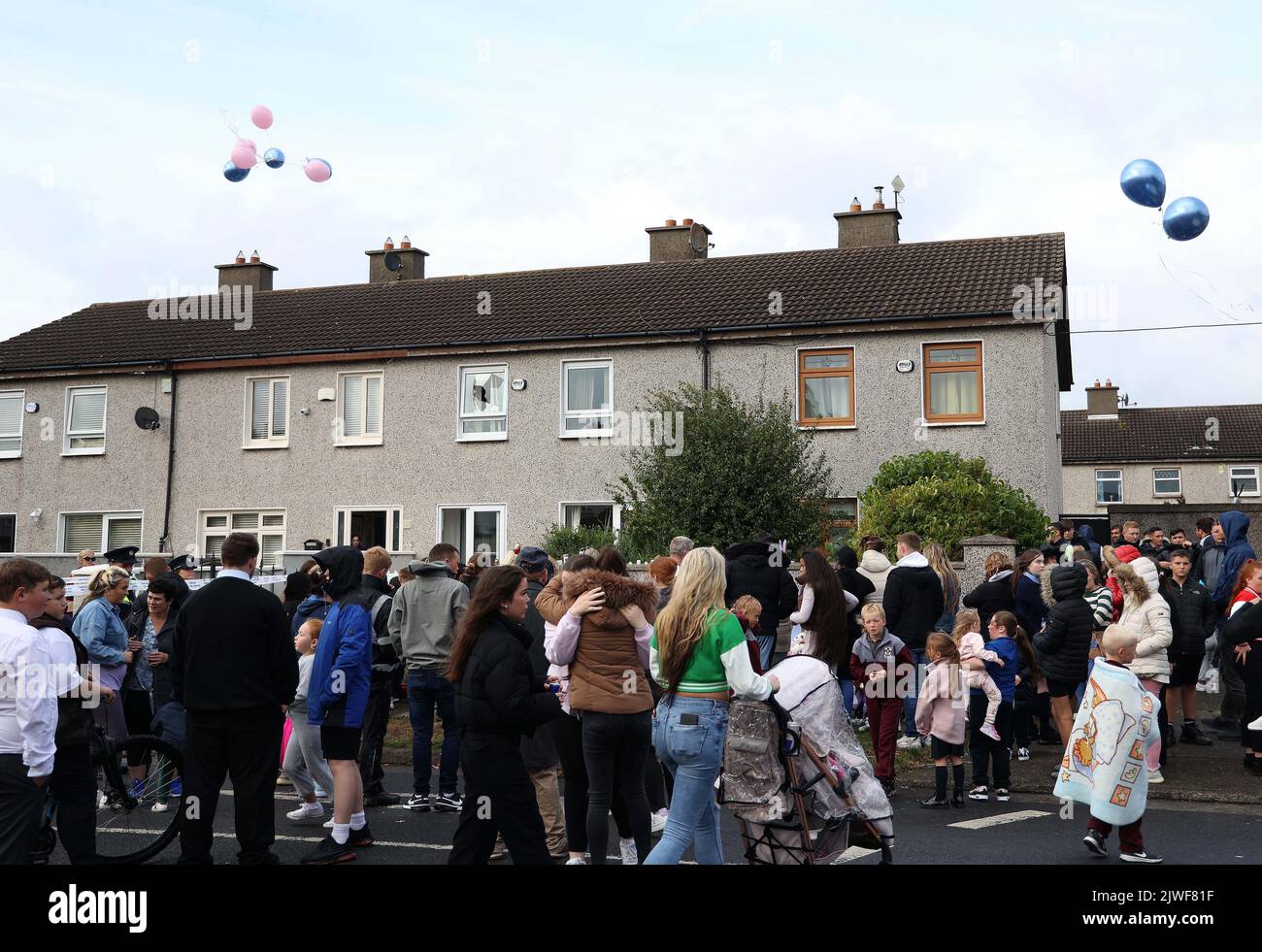People attend a vigil outside a house on Rossfield Avenue in Tallaght