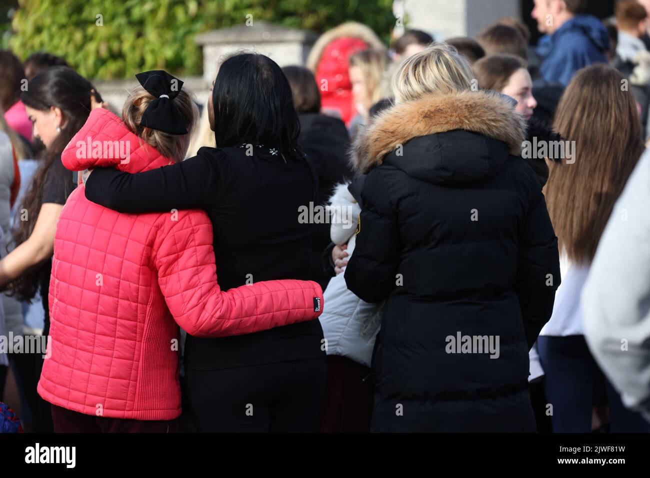 People attend a vigil outside a house on Rossfield Avenue in Tallaght