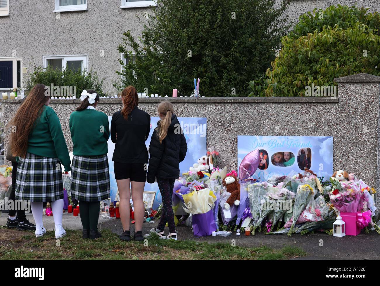 Flowers and candles left after a vigil outside a house on Rossfield