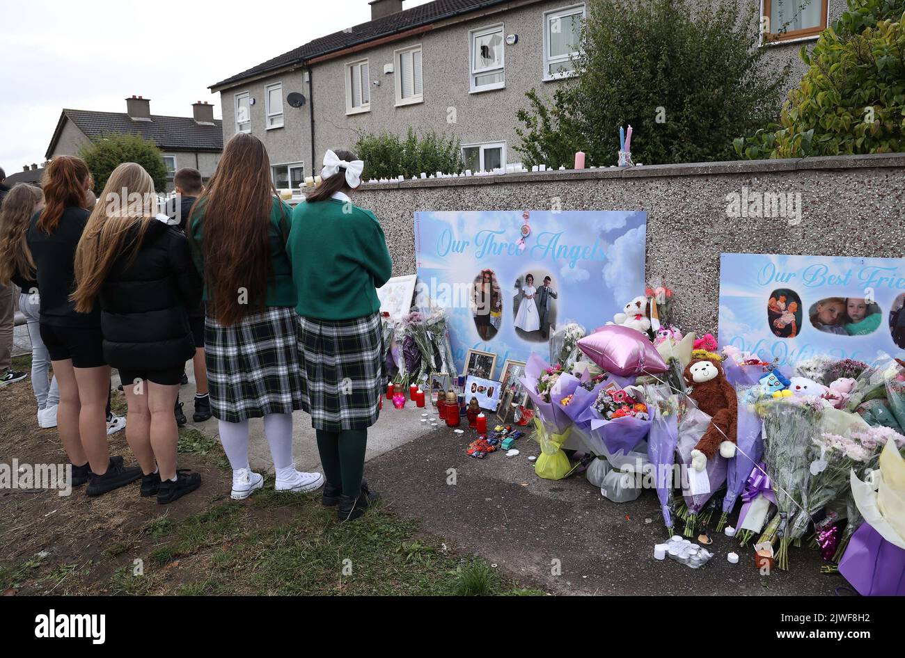 Flowers and candles left after a vigil outside a house on Rossfield