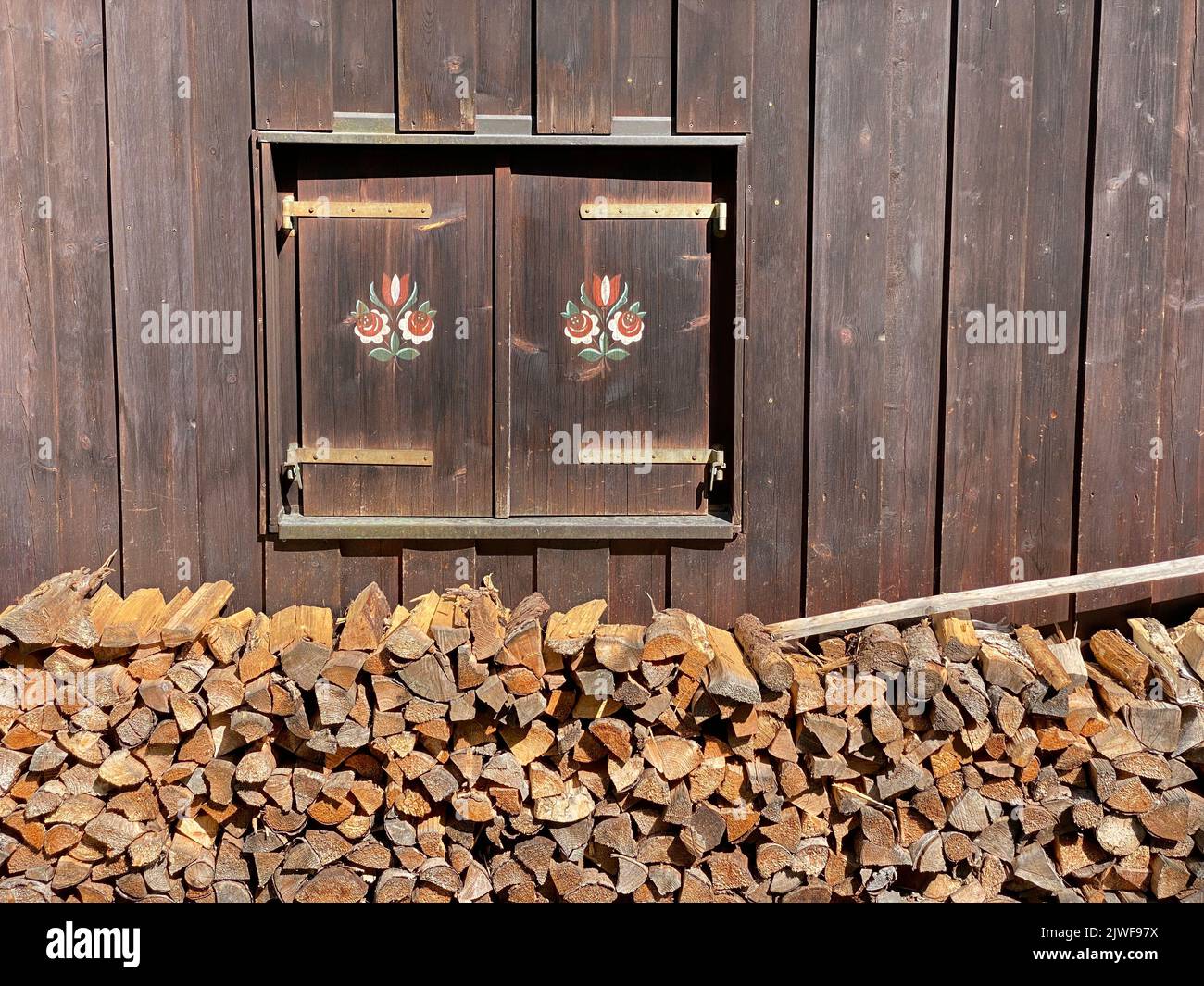 Closed Shutter With Painting And Firewood Stock Photo