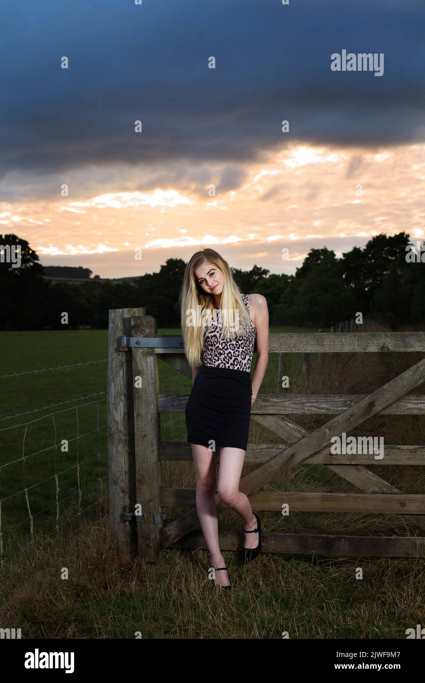 Skinny blonde caucasian teenager in a black mini skirt outdoors UK Stock Photo