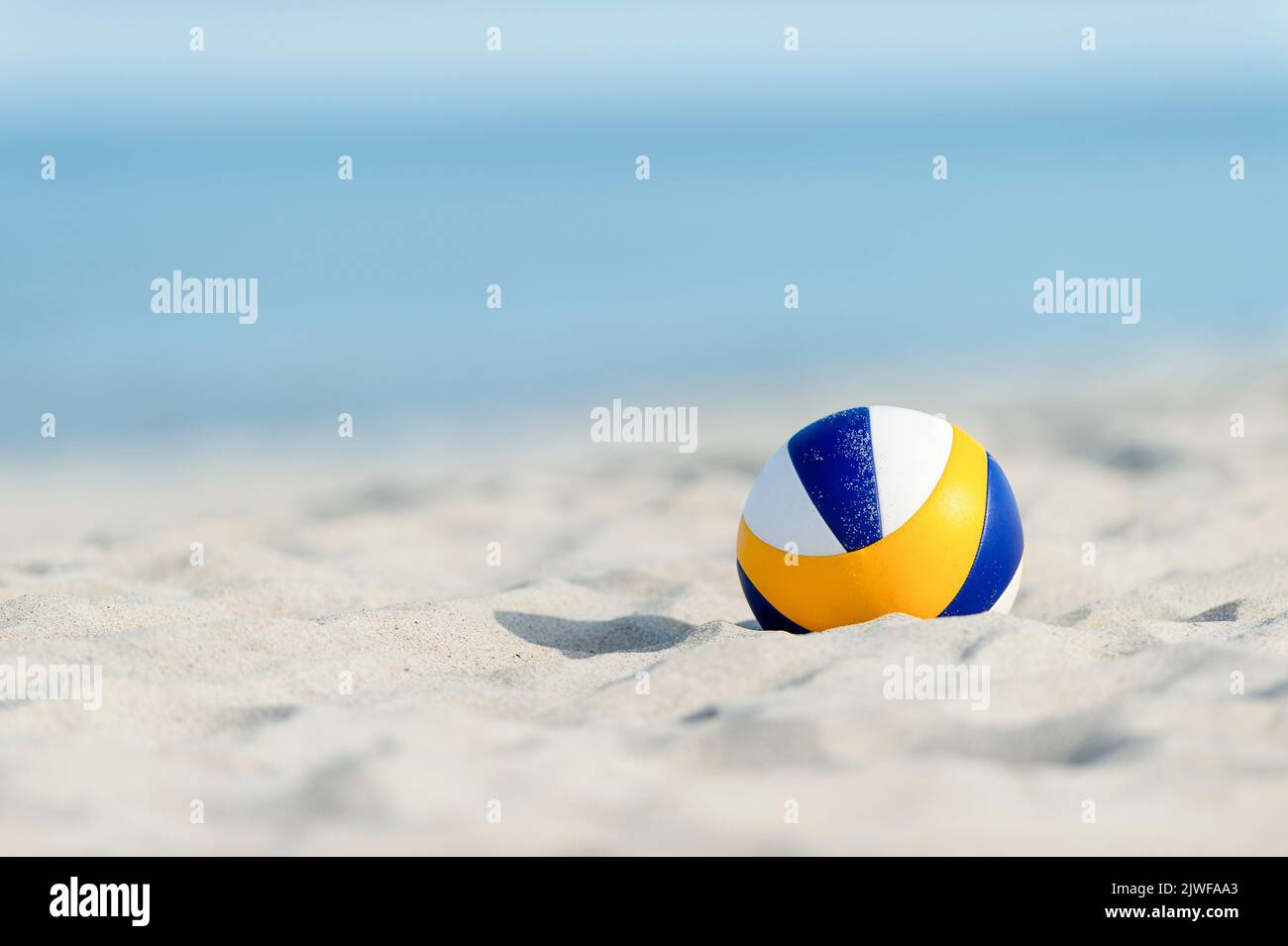 Beach volleyball ball on the sand beach. Horizontal sport theme poster, greeting cards, headers, website and app Stock Photo