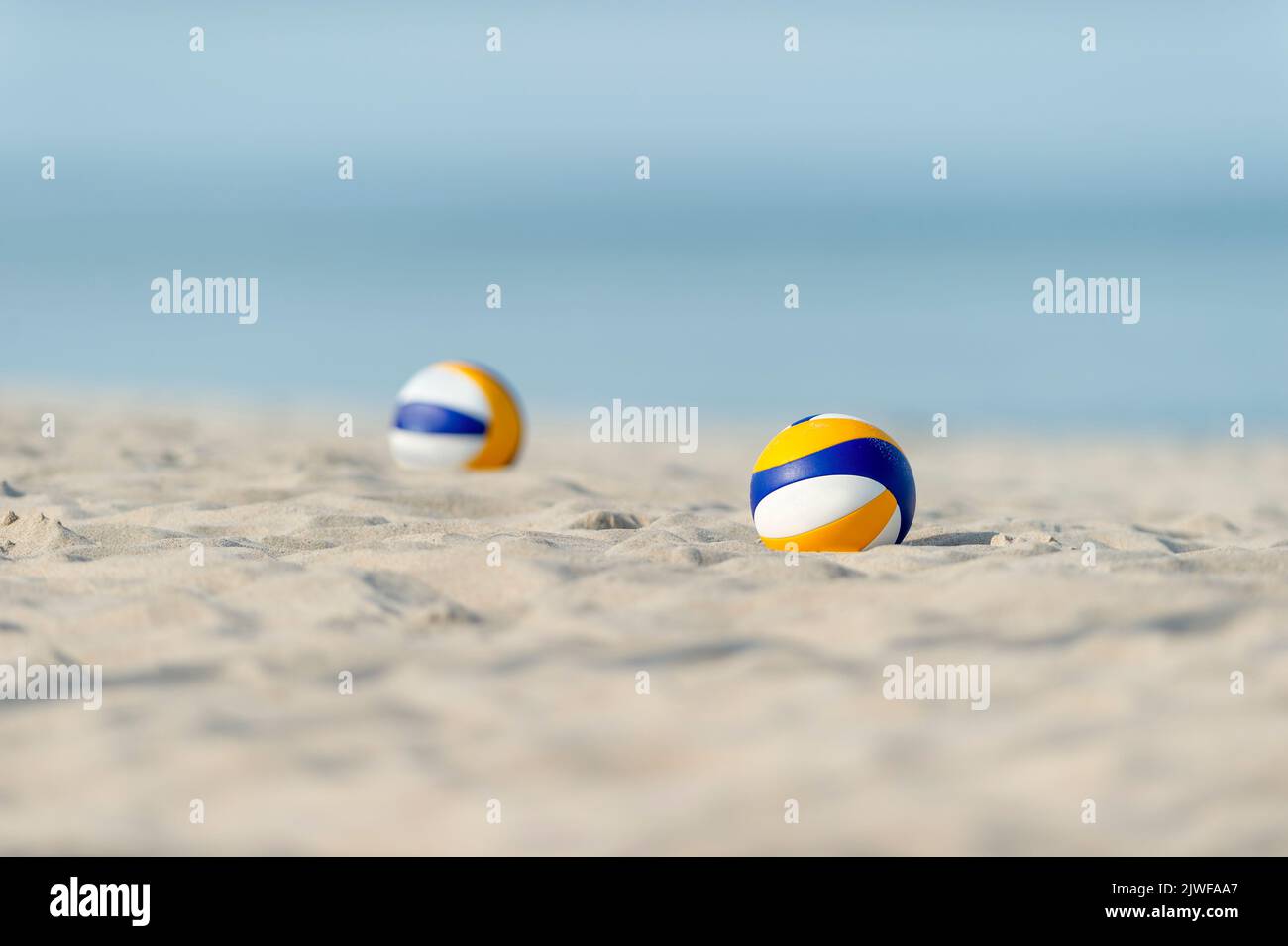 Beach volleyball balls on the sand beach. Horizontal sport theme poster