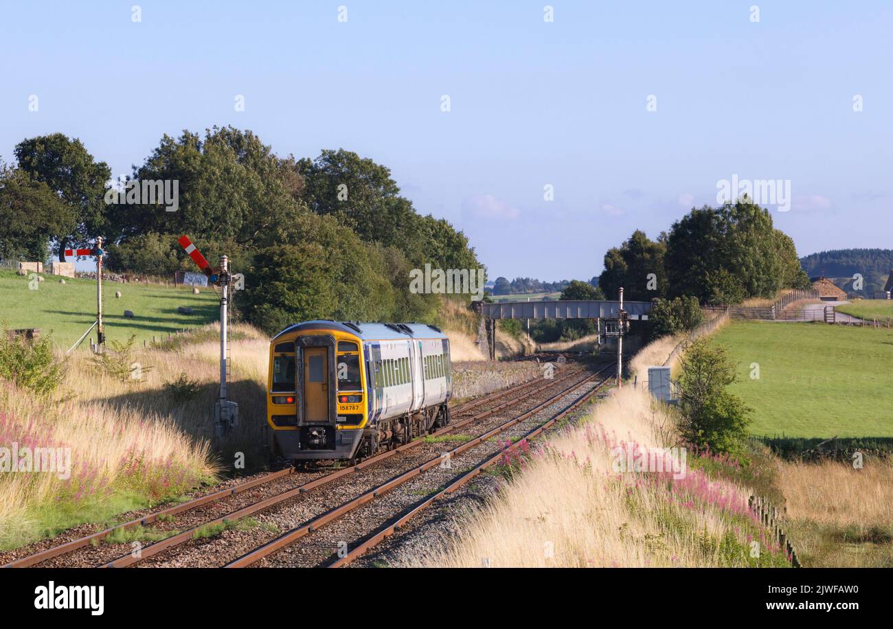 Northern rail class 158 Diesel multiple unit  train passing the mechanical semaphore signals at Settle junction, Yorkshire, UK Stock Photo