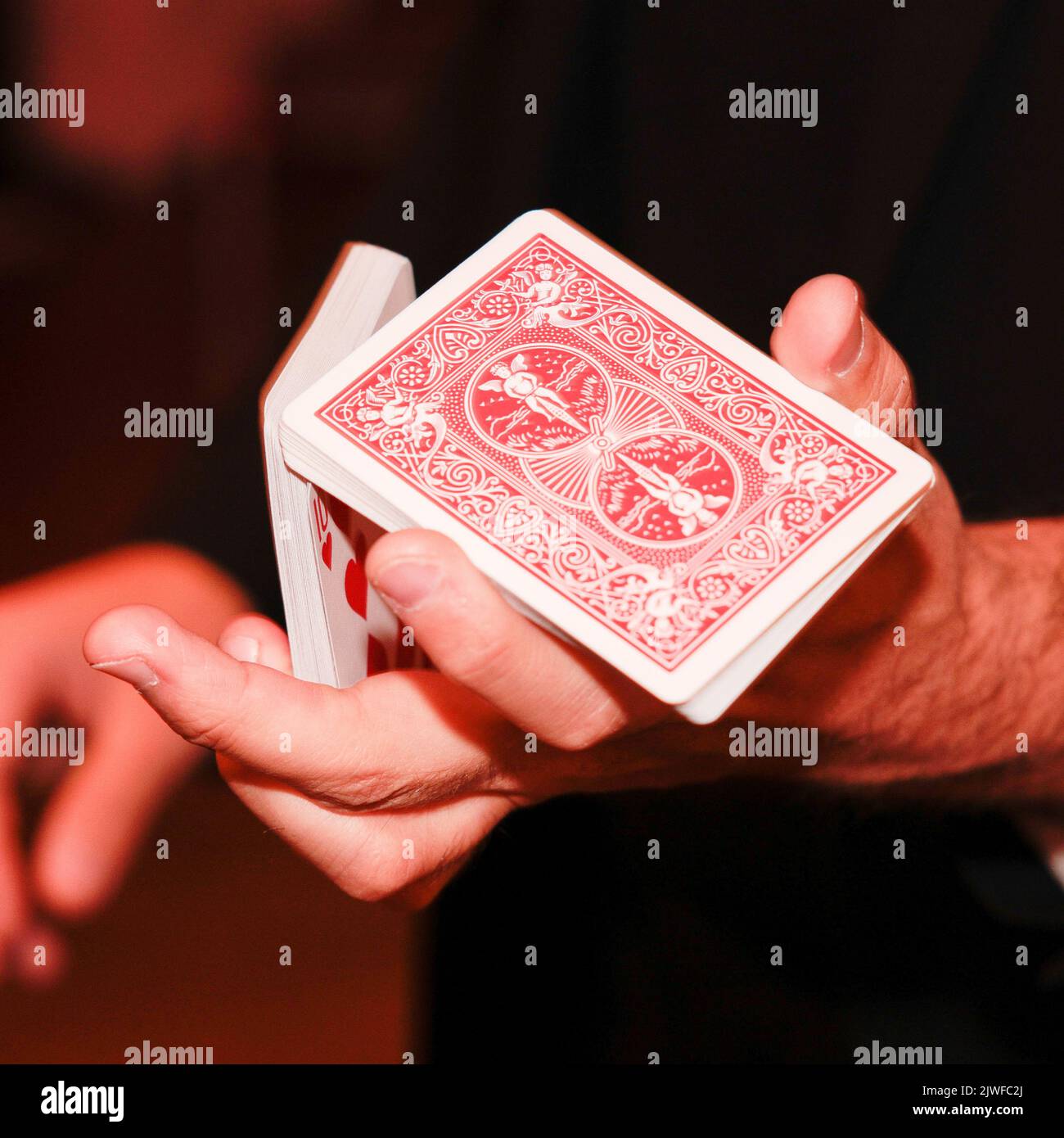 A close up of a cardsharp magician shuffling card Stock Photo