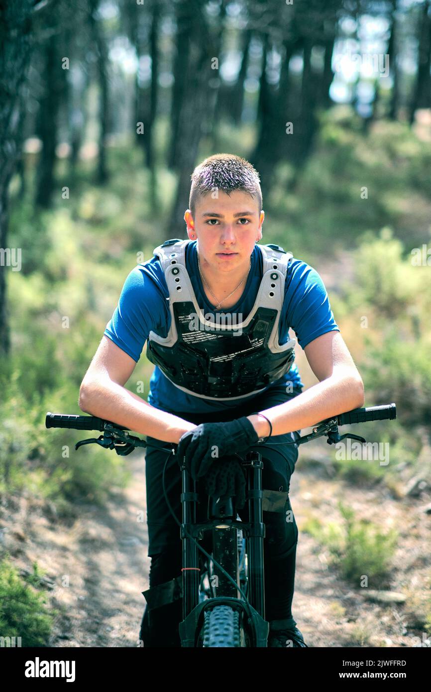 Teenager in forest with downhill bike. Stock Photo