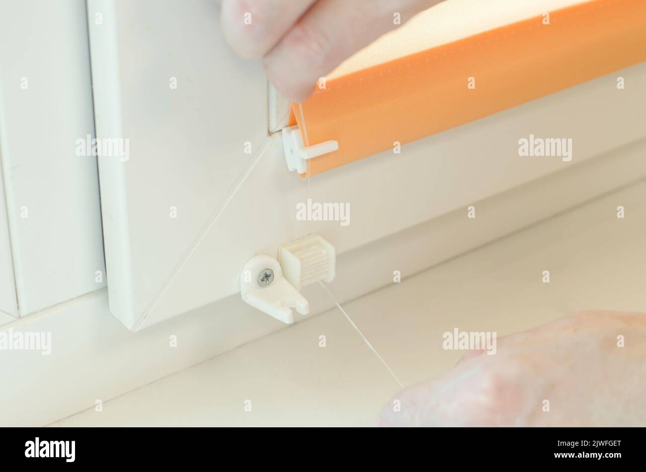 Assembly of roller blinds. Hands are assembling roller blinds, close-up Stock Photo