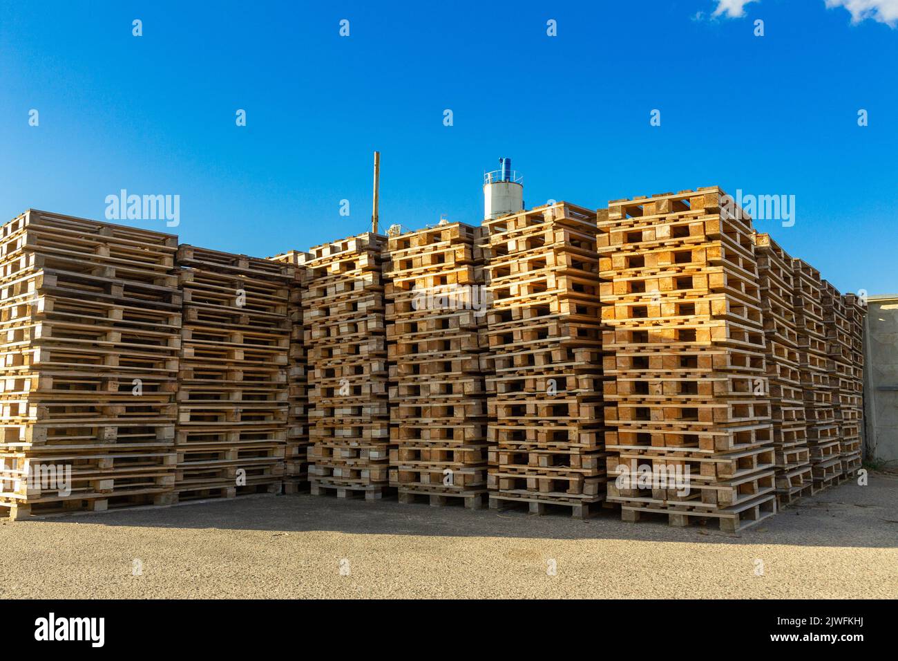 Stacks of wooden pallets in a warehouse yard of factory. Pallets for