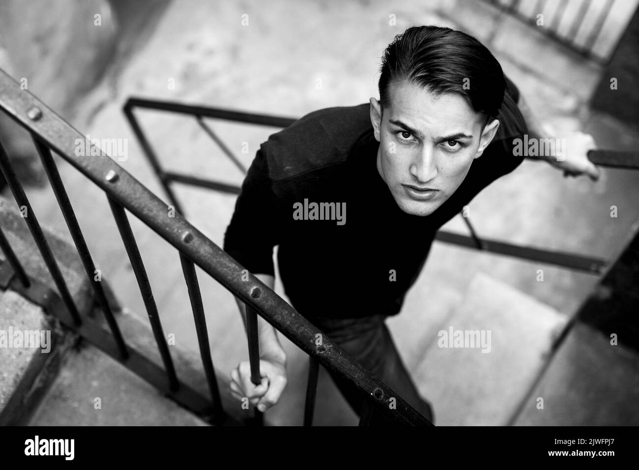 Portrait of a handsome young man on a street staircase. Black and white photo. Stock Photo