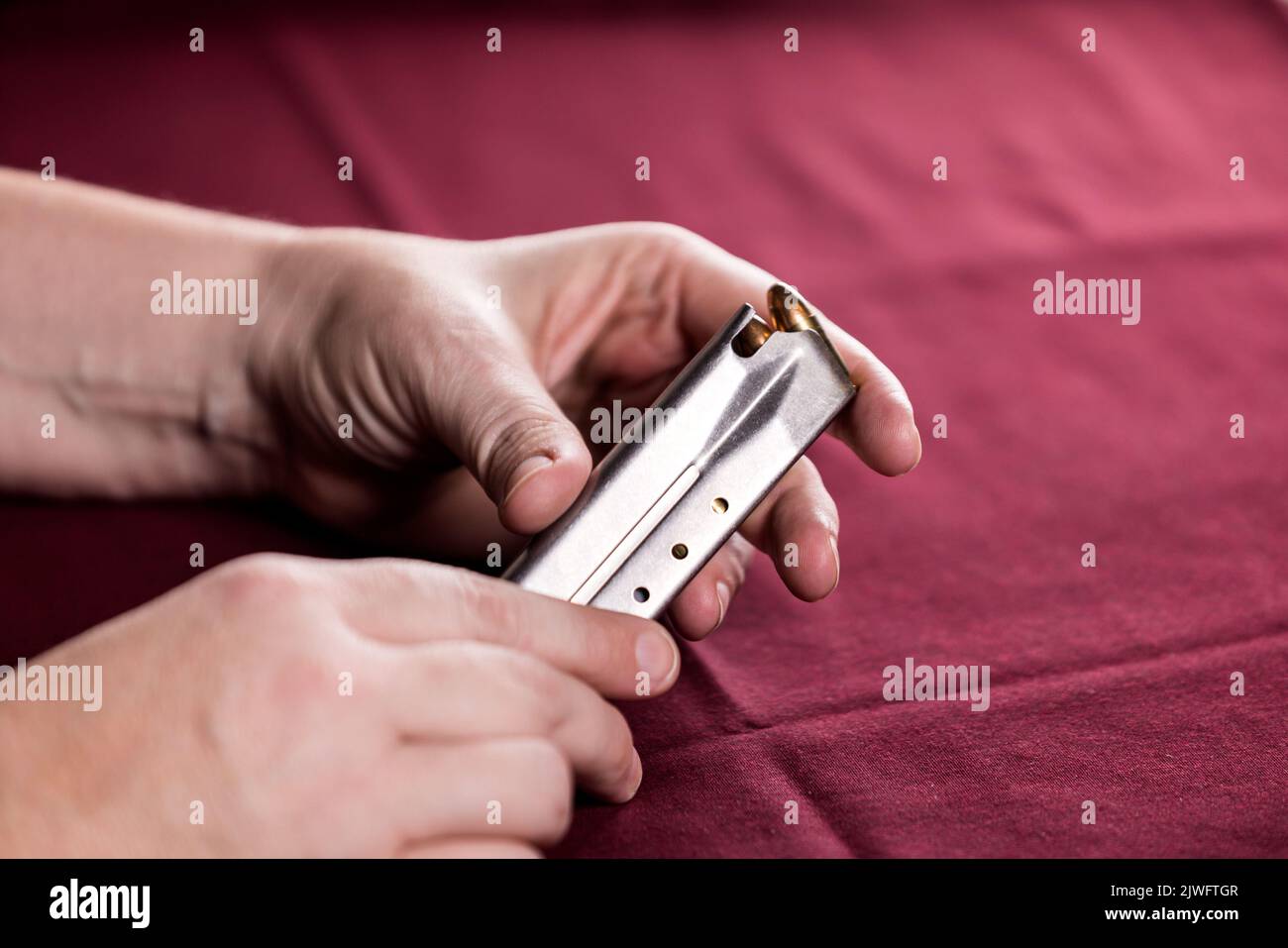 Hands holding a loaded magazine for a semiautomatic pistorl Stock