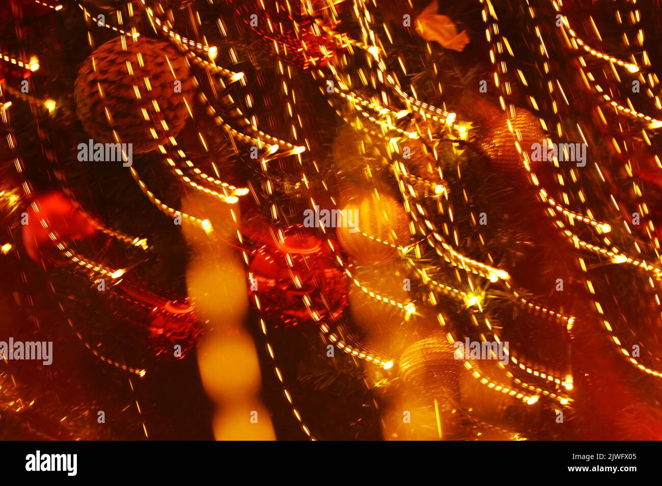Background material photo of golden Christmas illumination taken with panning and defocus Stock Photo