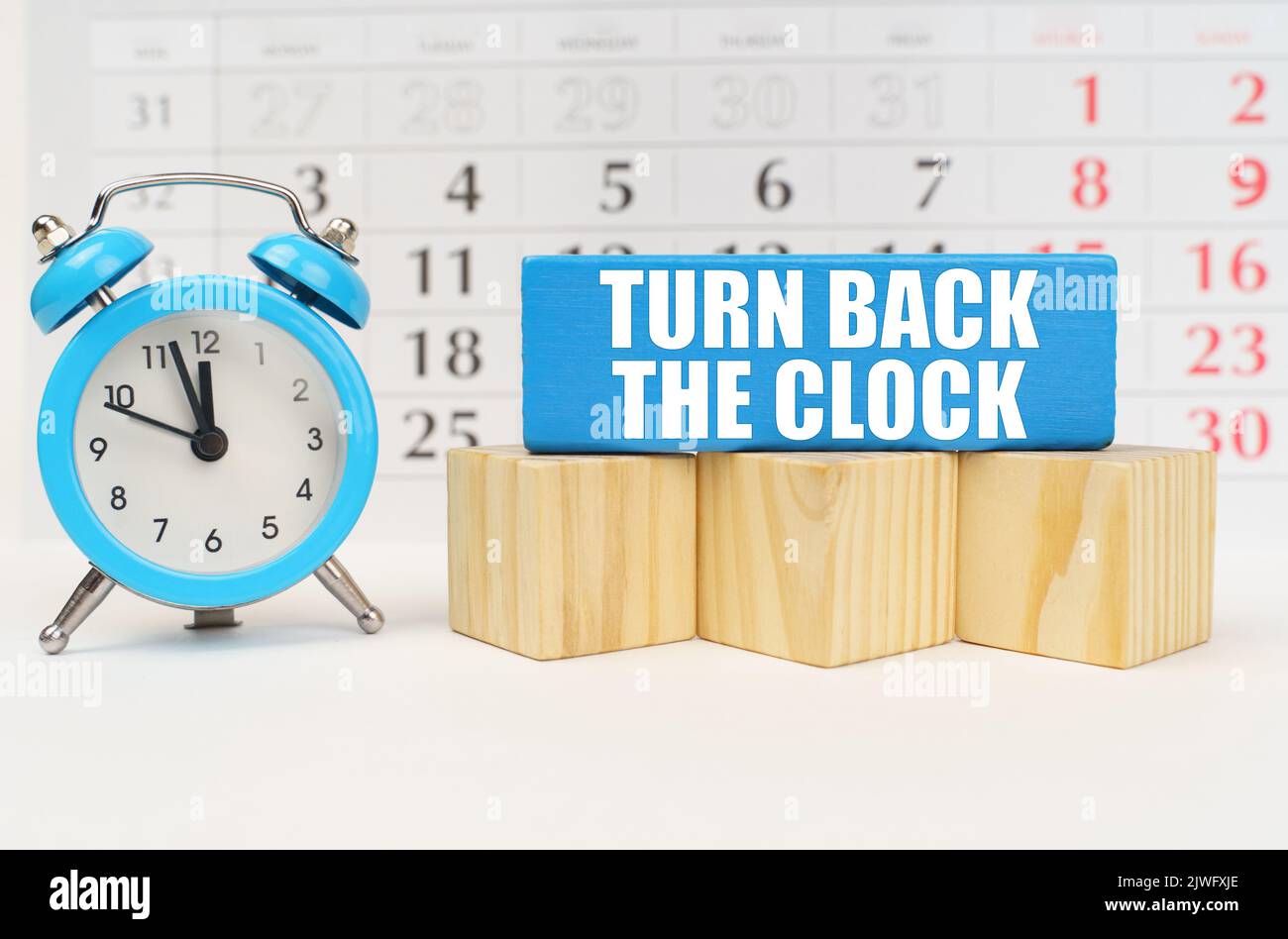 Time concept. Against the background of the calendar is an alarm clock