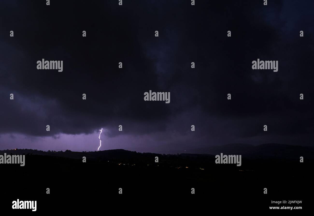 Halkyn Mountain, Flintshire, North Wales, UK. UK Weather. 5th September 2022 lightning strike over the village of Rhes-y-Cae with the Clwydian Range Hills in the distance ©DGDImages/AlamyNews Stock Photo
