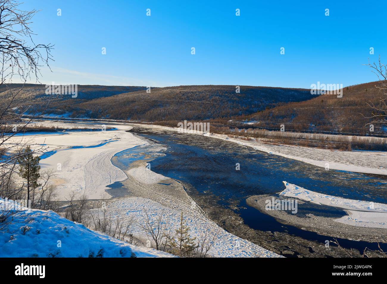 The river Tana in winter with ice floating and blue sky in morning with ...