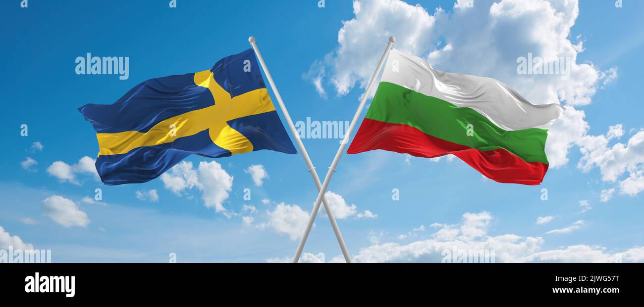 two crossed flags Bulgaria and Sweden waving in wind at cloudy sky ...