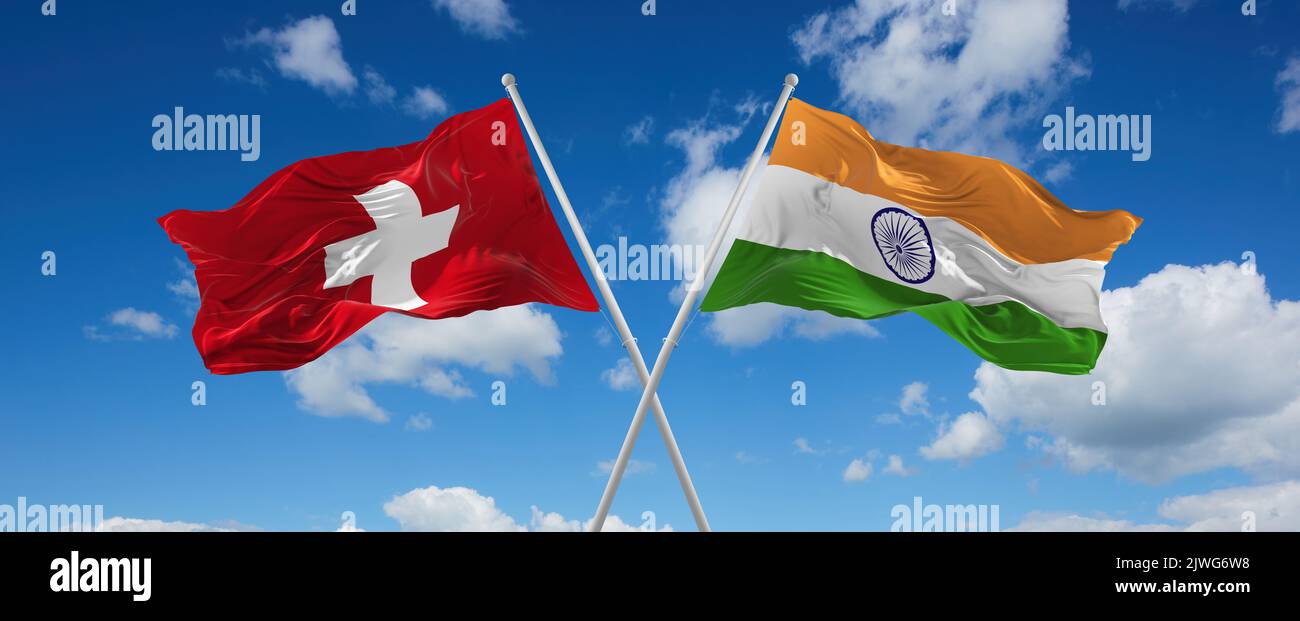 two crossed flags India and Switzerland waving in wind at cloudy sky ...