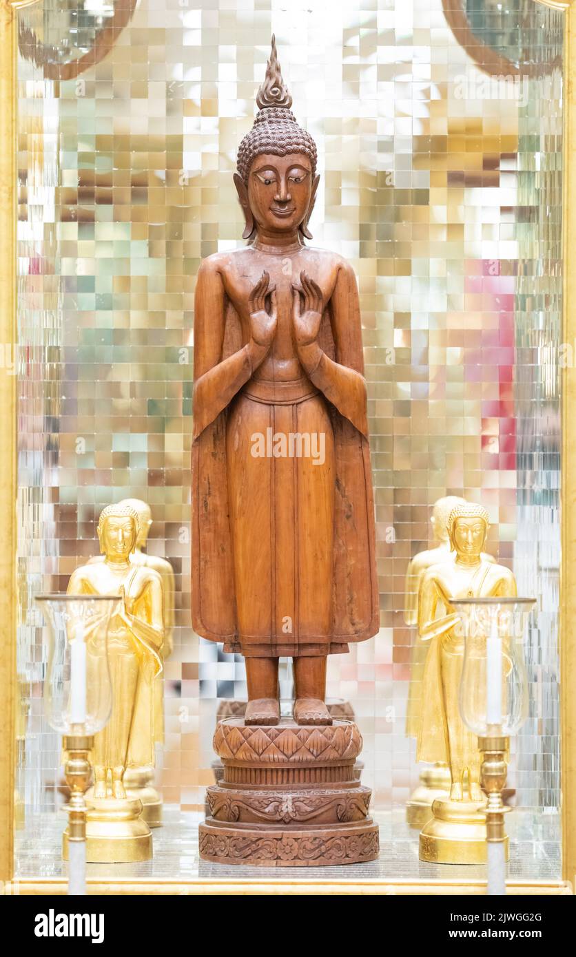 standing Buddha statue made of wood was placed between the smaller