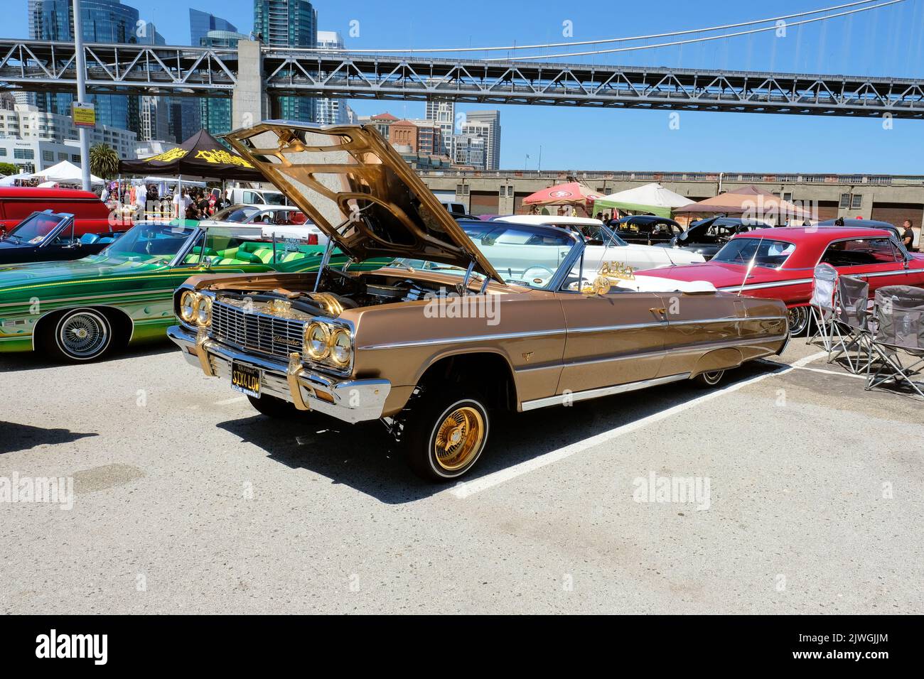 1964 Chevy Impala lowrider convertible in brown with gold trim; lowrider car culture at a car show at the Embarcadero in San Francisco, California. Stock Photo