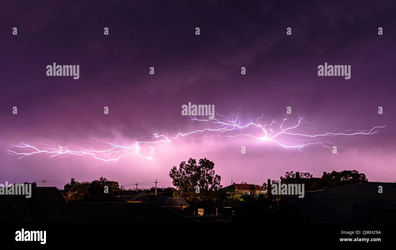 Lightning during a thunderstorm above residential buildings in Broken Hill, New South Wales Stock Photo